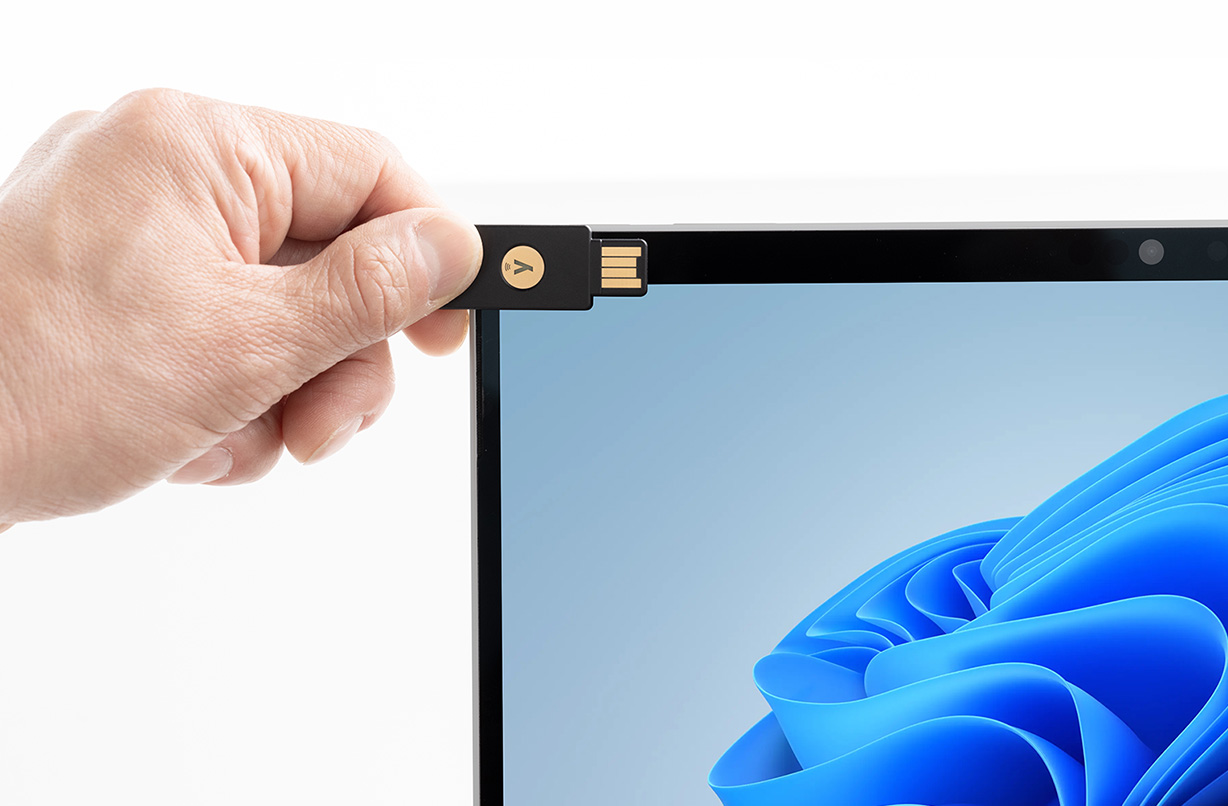 一个人在 Surface Pro 10 商用版上使用 NFC 读卡器，暗示设备上的各种内置安全措施。