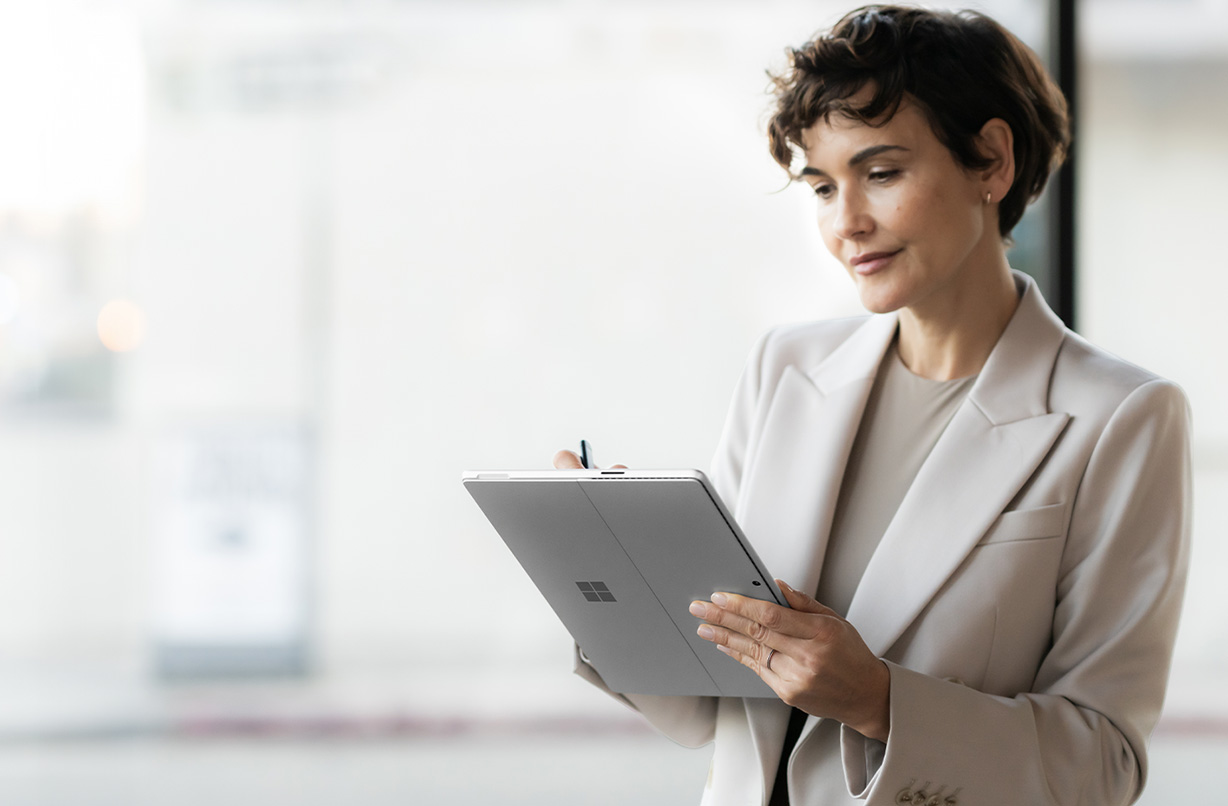 一个穿着西装的人在公共场所使用 Surface Pro 10 商用版，暗示了设备的安全性。