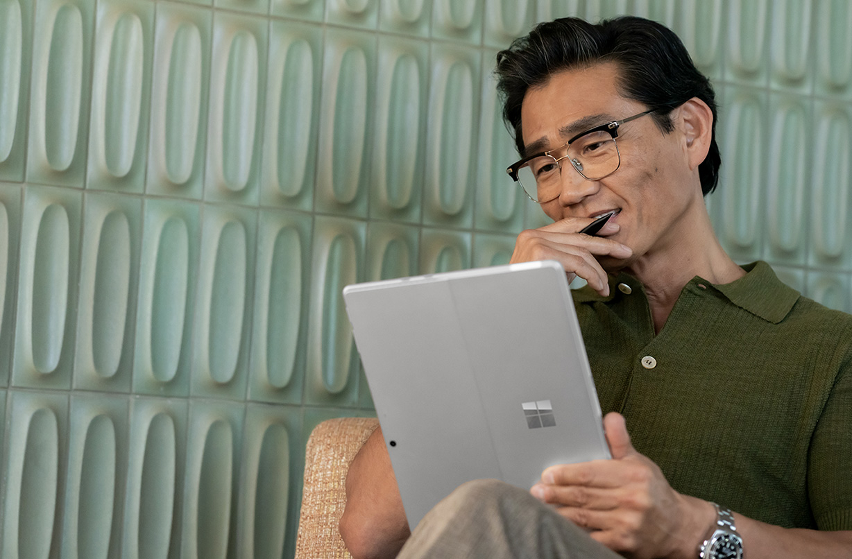 一个人将 Surface Pro 10 商用版作为平板电脑使用。