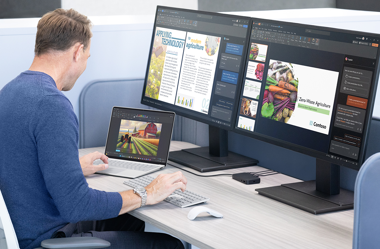 一个人在办公桌前工作，使用 Surface USB4 扩展坞将 Surface 笔记本电脑连接到两个外接显示器上。