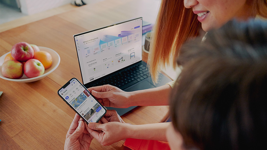 两个人分别在一台设备、一部手机上使用 Microsoft 365 应用。